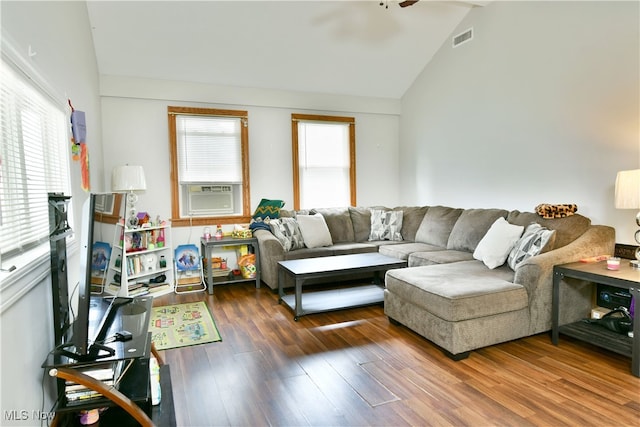 living room with cooling unit, lofted ceiling, plenty of natural light, and wood-type flooring