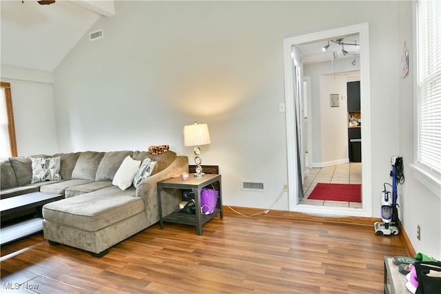 living room with vaulted ceiling with beams and hardwood / wood-style floors