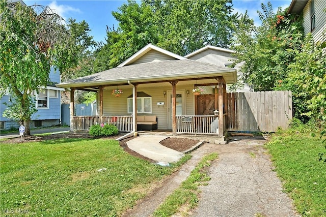 bungalow-style home featuring covered porch and a front lawn