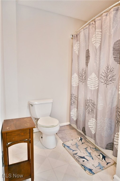 bathroom featuring a shower with shower curtain and toilet