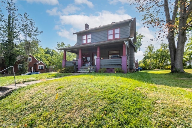 back of property featuring a porch and a yard