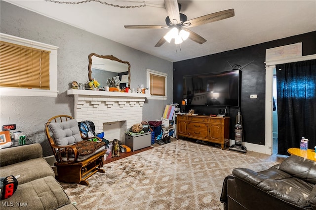 living room featuring a fireplace, ceiling fan, and carpet floors