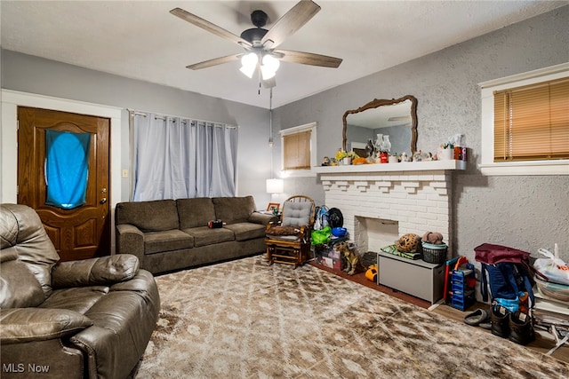 living room with ceiling fan, hardwood / wood-style floors, and a brick fireplace