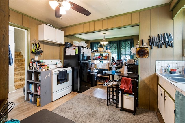 kitchen with light wood-type flooring, sink, black appliances, ceiling fan, and pendant lighting