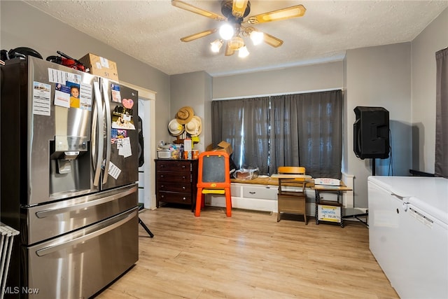 kitchen featuring a textured ceiling, light hardwood / wood-style flooring, ceiling fan, and stainless steel fridge with ice dispenser