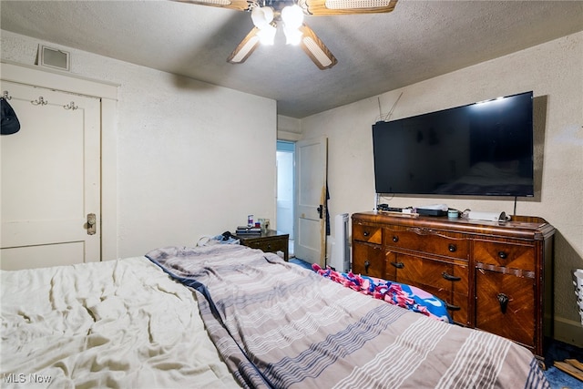 bedroom with a textured ceiling and ceiling fan