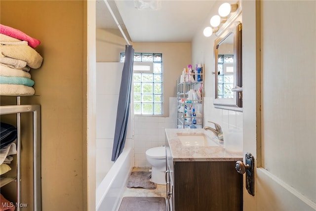 full bathroom featuring vanity, toilet, shower / bath combination with curtain, and tile walls