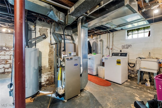 basement featuring water heater, independent washer and dryer, and sink