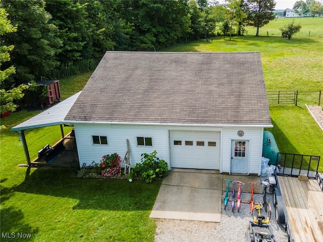 view of front facade featuring a garage, an outbuilding, and a front yard