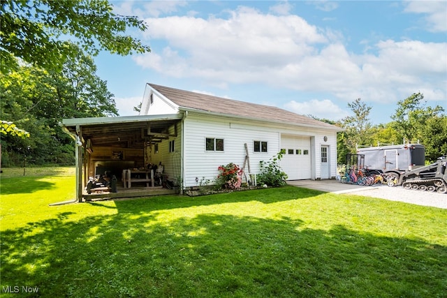 rear view of house featuring a garage and a lawn