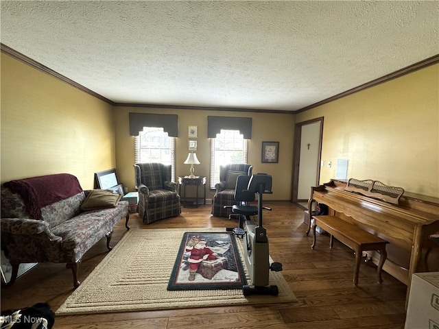 living room featuring wood-type flooring, ornamental molding, and a textured ceiling