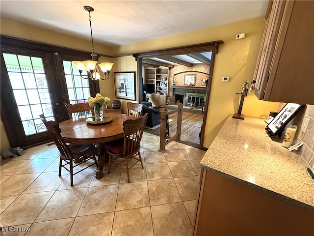 dining room featuring a textured ceiling, a chandelier, and light tile patterned flooring