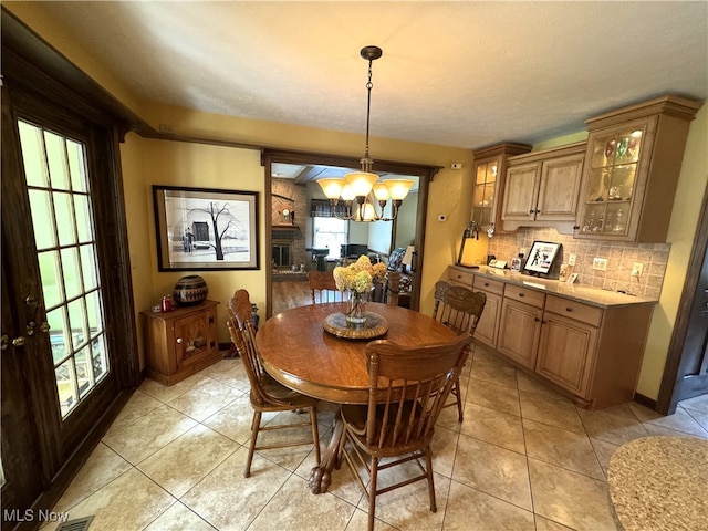 dining area featuring a wealth of natural light, a chandelier, and light tile patterned flooring