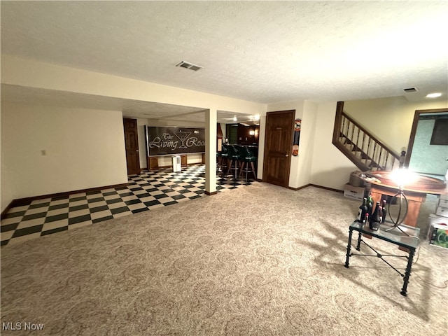 carpeted living room featuring a textured ceiling