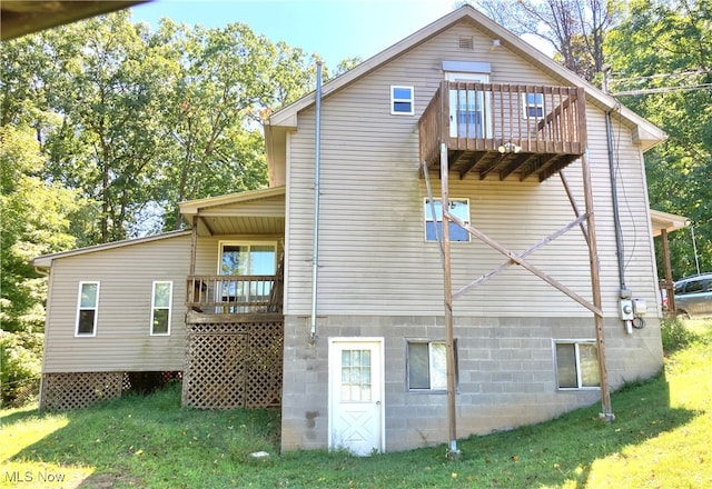 view of home's exterior with a balcony and a lawn