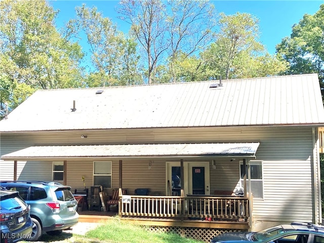 rear view of house featuring covered porch