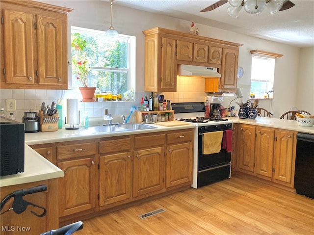 kitchen featuring dishwasher, light wood-type flooring, white gas range oven, and backsplash