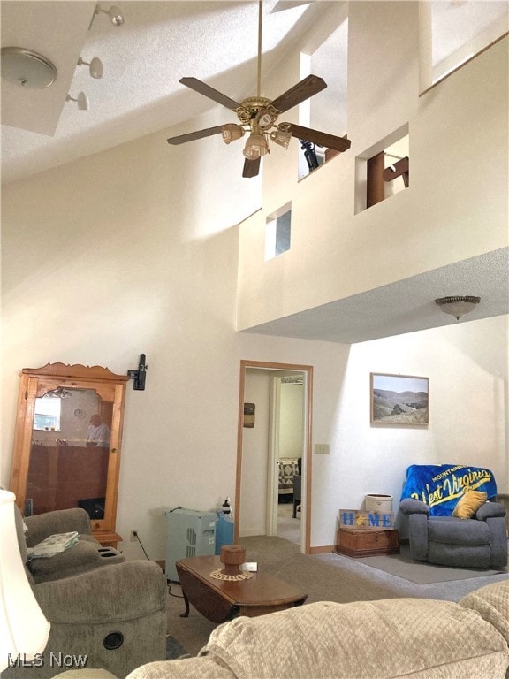 living room with high vaulted ceiling, ceiling fan, carpet, and a textured ceiling