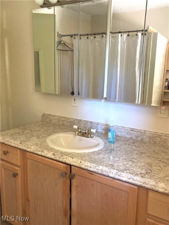 bathroom with a shower with curtain and vanity