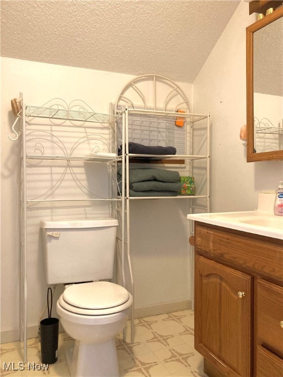 bathroom featuring vanity, toilet, and a textured ceiling