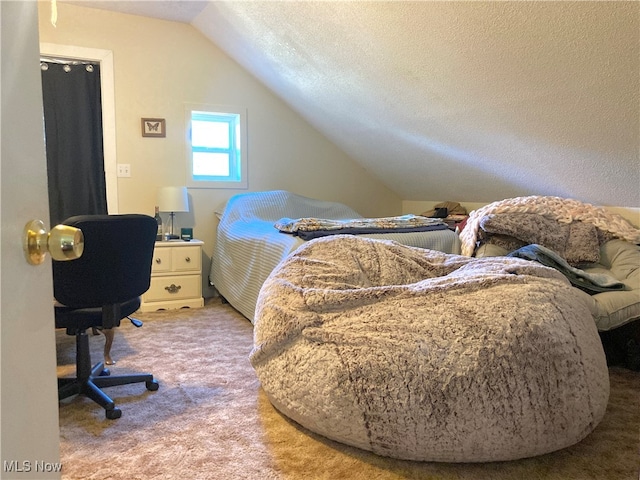 bedroom with a textured ceiling, lofted ceiling, and carpet