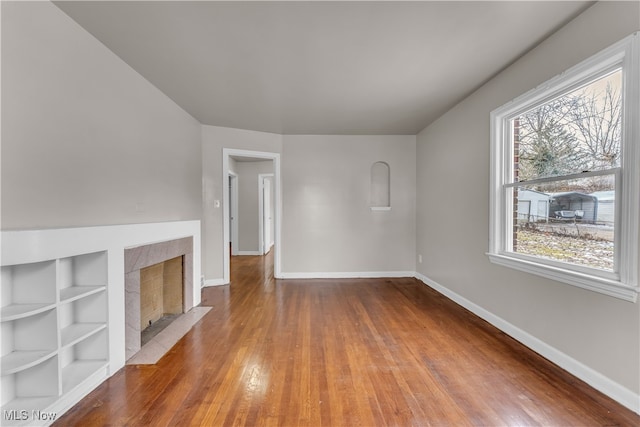 unfurnished living room featuring wood-type flooring and a fireplace