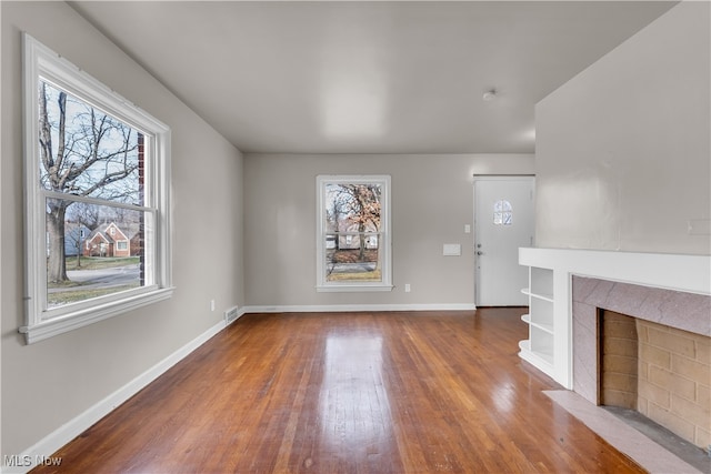 unfurnished living room featuring dark hardwood / wood-style flooring and a premium fireplace