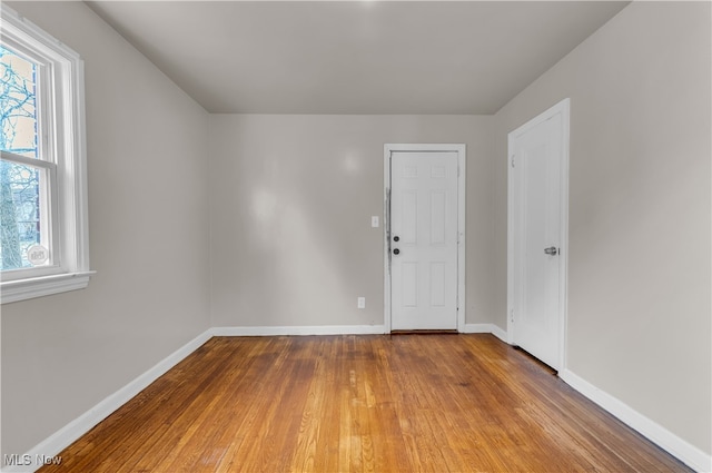 spare room with plenty of natural light and hardwood / wood-style floors