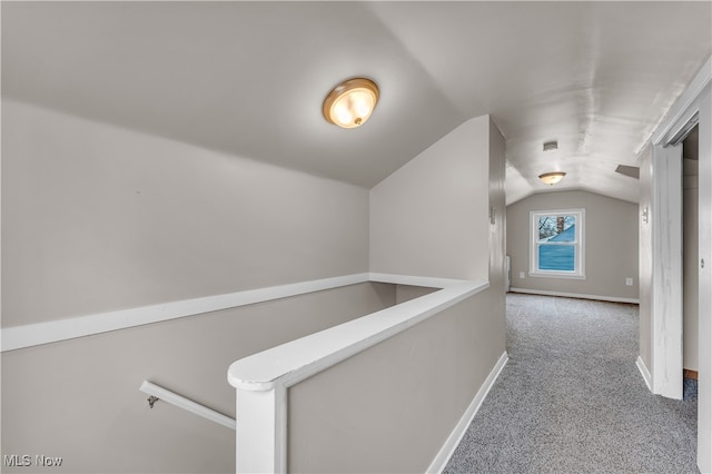 hallway with lofted ceiling and carpet flooring