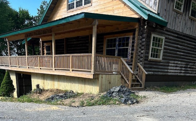 view of side of property with log siding and metal roof