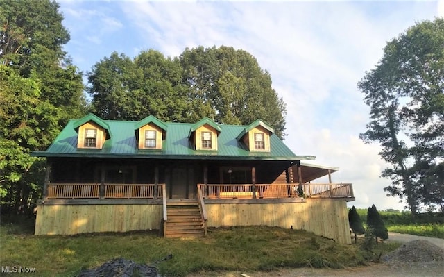 view of front of home with metal roof, a porch, and stairway