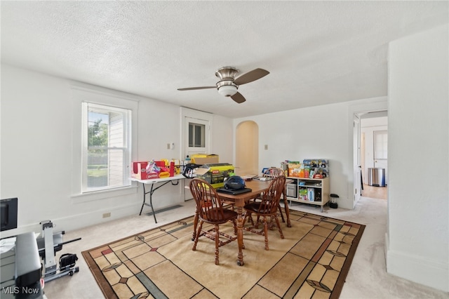 carpeted dining room with ceiling fan and a textured ceiling