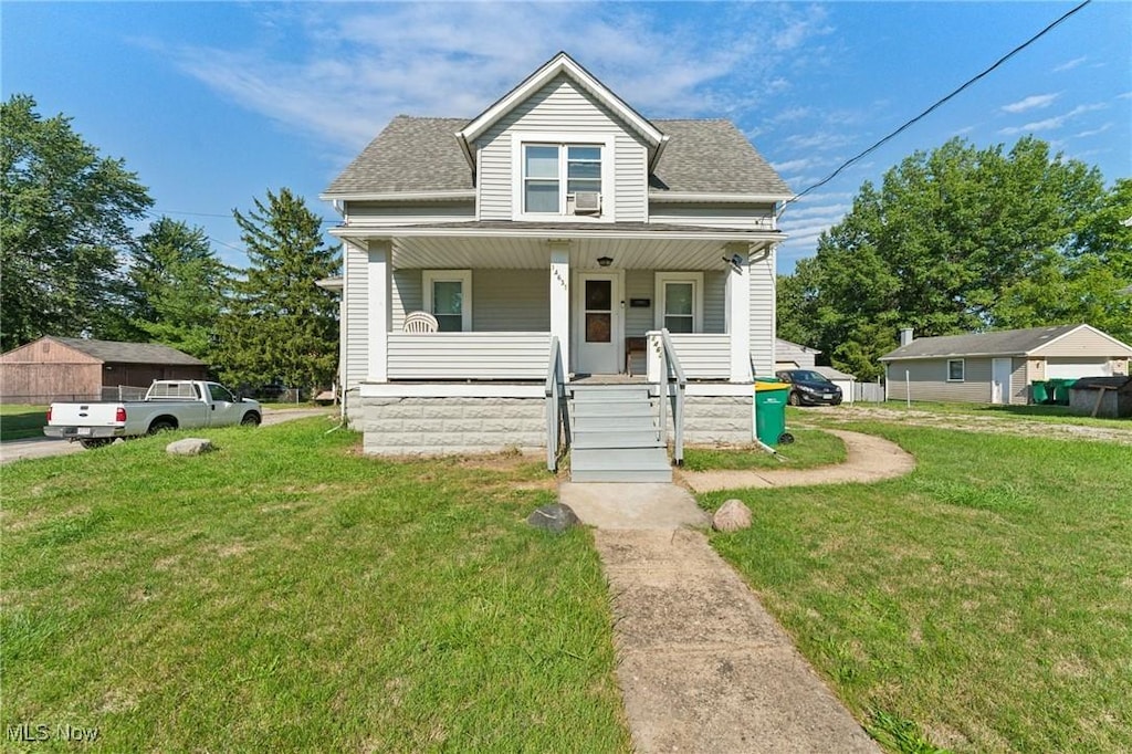 view of front of house with a porch, a front yard, and roof with shingles