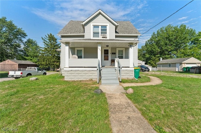 view of front of house with a porch, a front yard, and roof with shingles