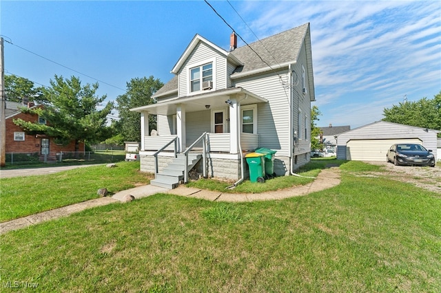 bungalow-style home with a garage, a porch, a front lawn, and an outdoor structure