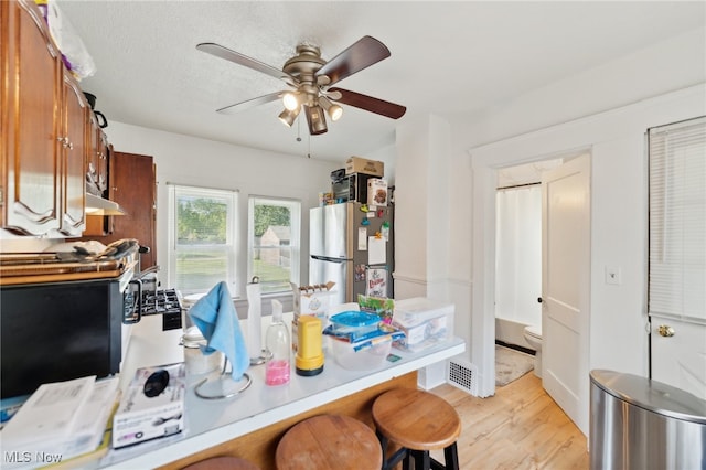 office space featuring light wood-type flooring, ceiling fan, and a textured ceiling