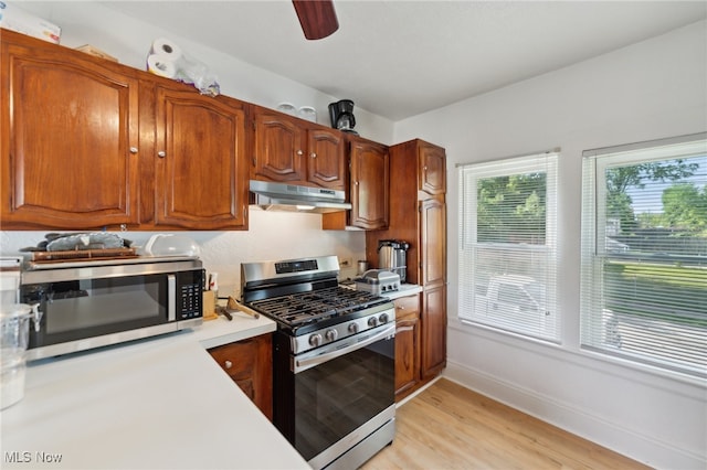 kitchen with light wood-type flooring, appliances with stainless steel finishes, and ceiling fan