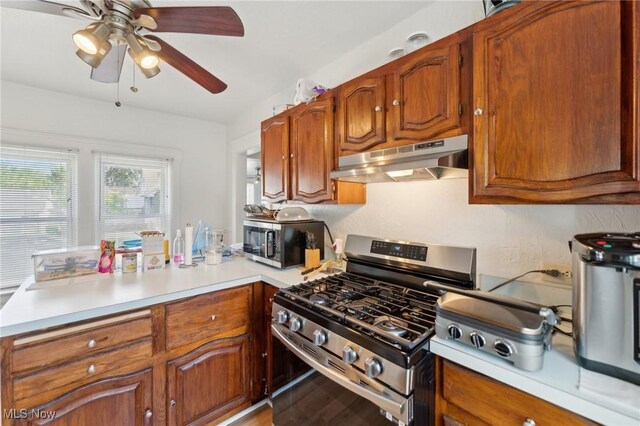 14631 Granger Rd, Maple Heights, OH 44137 - kitchen featuring under cabinet range hood, stainless steel appliances, a peninsula, light countertops, and brown cabinets