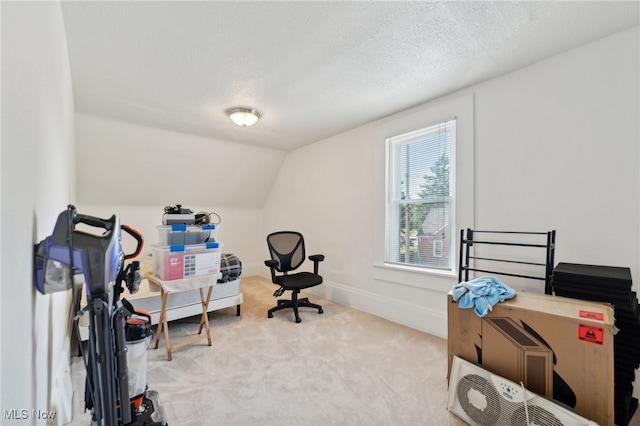 office area featuring vaulted ceiling, a textured ceiling, and light colored carpet