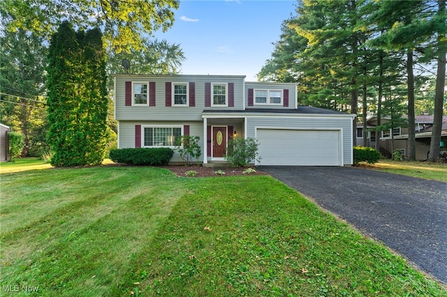 view of property with a garage and a front lawn