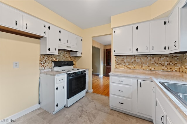 kitchen featuring white range oven, tasteful backsplash, premium range hood, and white cabinets