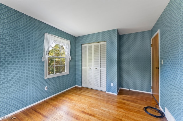 unfurnished bedroom with a closet and light hardwood / wood-style floors