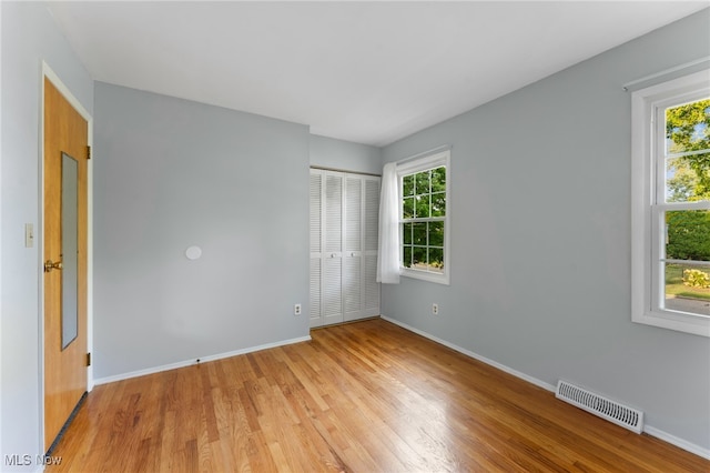 unfurnished room with plenty of natural light and wood-type flooring