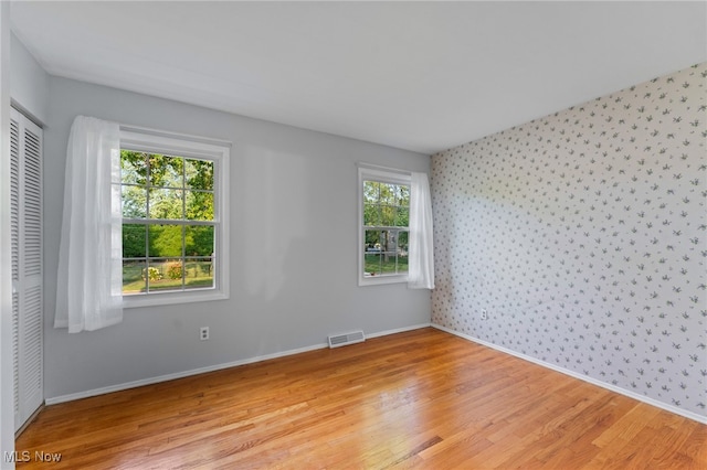 unfurnished room with a wealth of natural light and light hardwood / wood-style floors