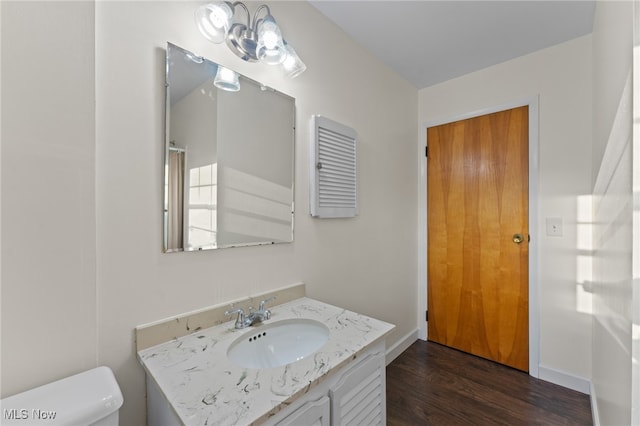 bathroom featuring vanity, toilet, and hardwood / wood-style flooring