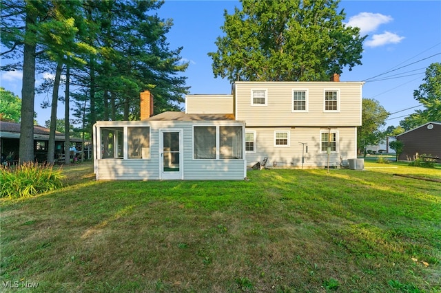 back of house featuring cooling unit and a lawn