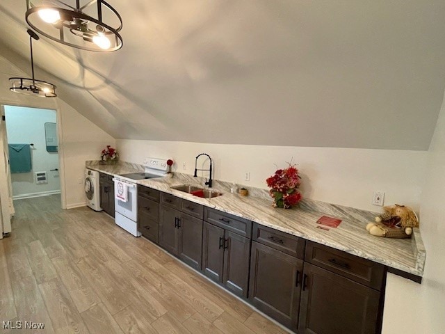 kitchen featuring washer / dryer, white electric range, vaulted ceiling, pendant lighting, and light hardwood / wood-style floors