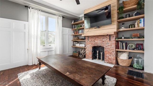 home office featuring ceiling fan, dark hardwood / wood-style floors, ornamental molding, and a brick fireplace