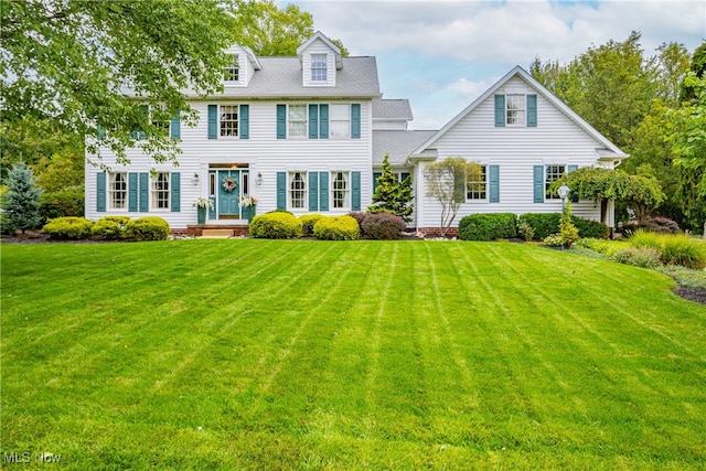 colonial-style house featuring a front yard