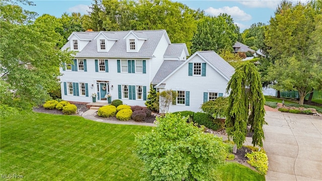 colonial inspired home with a front lawn